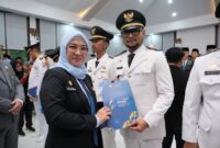 Bupati Gowa, Sitti Husniah Talenrang menyerahkan SK kepada Camat Parangloe yang baru, Riskhy di sela acara pelantikan pejabat eselon III-IV di Baruga Tinggimae, Kamis, (23/4/2026).
